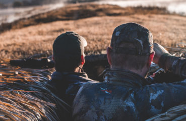 Two duck hunters wait in a hunting blind