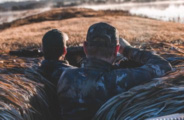 Two duck hunters wait in a hunting blind