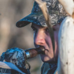 A goose hunter uses a call while hunting