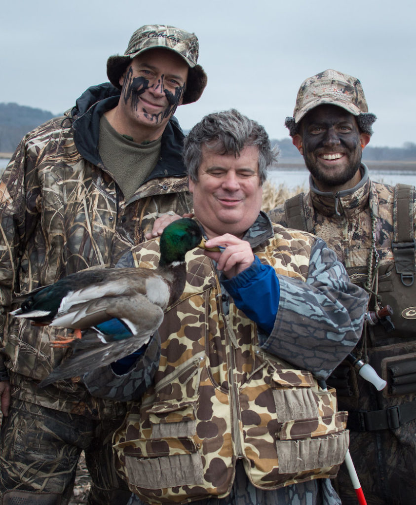 A blind hunter and two able-bodies helping with the harvest of his trophy mallard