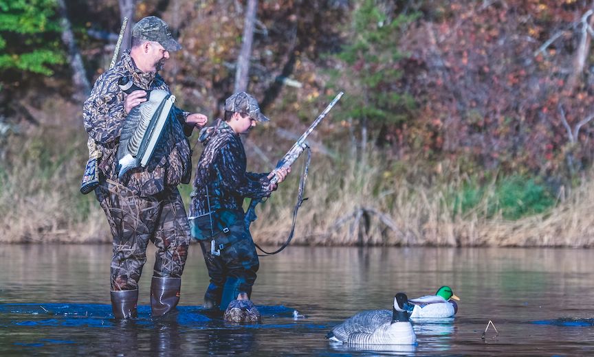 A mentor helps a young hunter set duck and goose decoys
